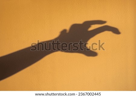 big monster claw shadow on wall. Horror hand shadow on a dark background, copy space. Royalty-Free Stock Photo #2367002445