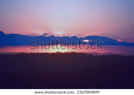 sunset or sunrise in real sky and fantastic sun with shine lines and clouds, natural colors in a panoramic background