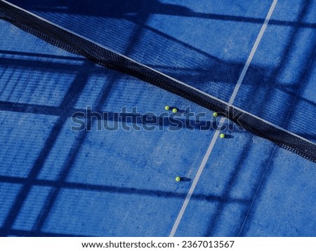 aerial drone view of a paddle tennis court net and five balls Royalty-Free Stock Photo #2367013567