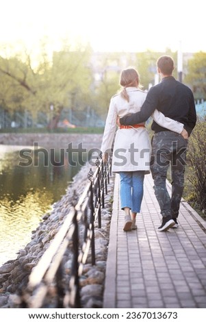 A man and a girl in love on a first date in autumn city park.