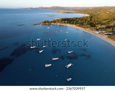 Picture of sunrise in Corsica: (Palombaggia) with boats, turquoise water and trees in the foreground.