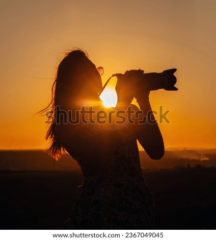 female photographer silhouette at dusk