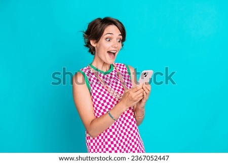 Photo of young funny surprised bob brown hair lady shocked watch her phone ebanking received money isolated on aquamarine color background