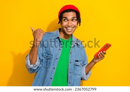 Photo of satisfied funky guy man wear trendy shirt braids red hat hand direct empty space cool offer isolated on yellow color background