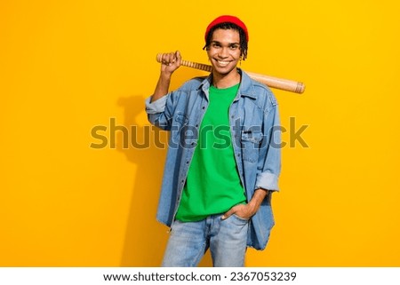 Photo of positive attractibve guy street gangster wear stylish denim clothes hold baseball bat isolated on yellow color background