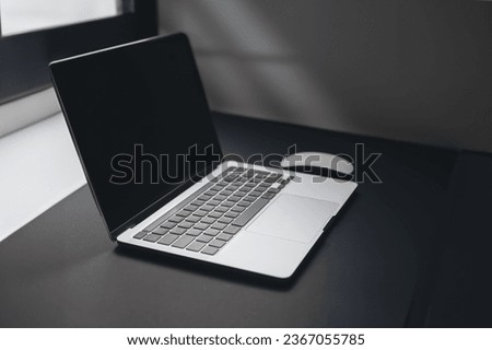 a laptop on table near window