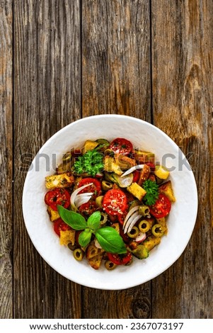 Italian style food - panzanella salad on wooden table 