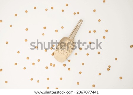 chickpea flour in spoon and chickpeas on white background top view