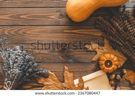 Autumn background top view, candle and leaves on wooden background.