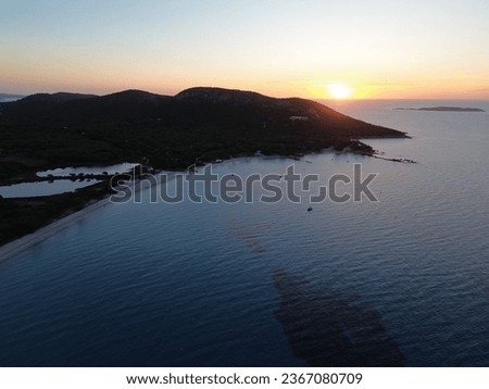 Picture of sunrise in Corsica: (Palombaggia) with turquoise water in the foreground and mountains in the background.