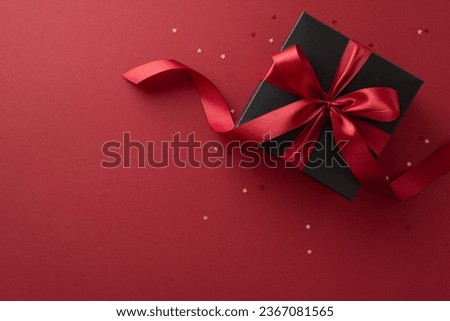 Black Friday surprise: Top view of a deluxe black gift box featuring a stylish red ribbon and gold confetti on a marsala background, offering an ideal spot for your text or ad