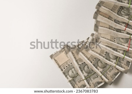 Many bundles of five hundred Indian rupee notes shot from above on white background. Indian rupee currency notes with clear white background for text. Royalty-Free Stock Photo #2367083783