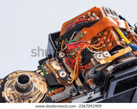 A dissassembled SLR 35mm film camera, top casing removed to show the electronic parts and circuits. Concept for camera repair service, photographic mechanical components and electronics. Copy space. Royalty-Free Stock Photo #2367092909