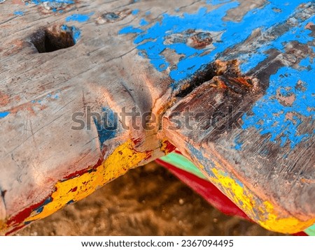 The wooden texture of a boat with the paint peeling off