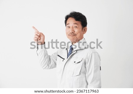 Asian middle aged worker pointing side in white background