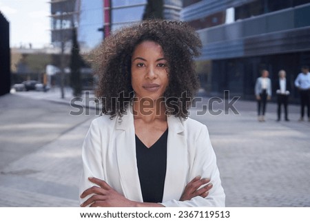 Portrait of serious middle-aged African American business woman looking at camera arms crossed. Confident female formal wear afro hair poses outside office center. Copy space staff earnest people. Royalty-Free Stock Photo #2367119513
