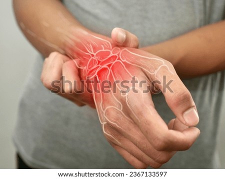 Anonymous person touching his wrist, suferring from arthritis disease, close up against grey background Royalty-Free Stock Photo #2367133597