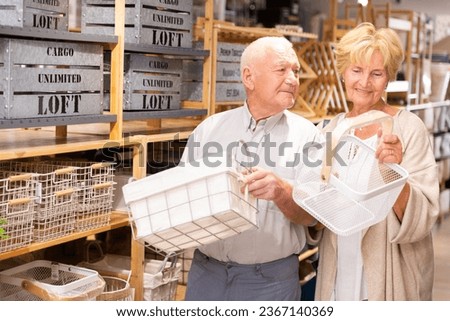 Positive couple elderly customers buying storage baskets in a household goods store Royalty-Free Stock Photo #2367140369