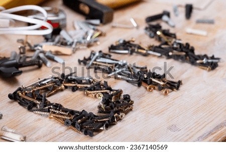 Bunch of different screws on a wooden surface. High quality photo