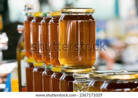 A row of natural jars of honey for sale at the stall of a green market vendor in Tetovo, North Macedonia in the former Yugoslavia. Dark yellow colour. Royalty-Free Stock Photo #2367171029