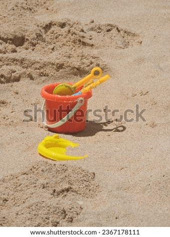 children's toys on the orange and yellow beach sand
