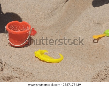 children's toys on the orange and yellow beach sand