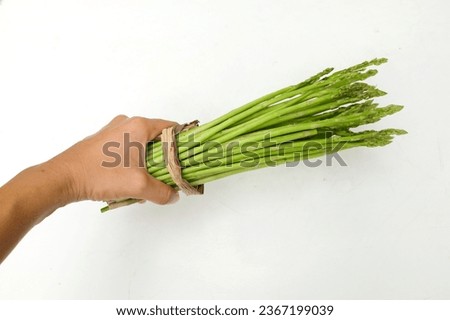 Asian man holding Fresh  green raw vegetables asparagus (Asparagus officinalis) isolate on a white backdrop. Vegan healthy food.
vegetable for healthy nutrition