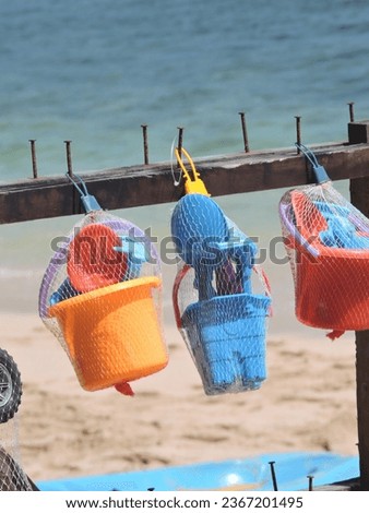Colorful children's toys are hung on wood on the beach

