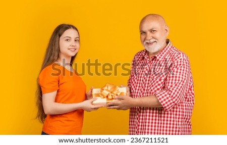 happy child and grandfather with present box for anniversary