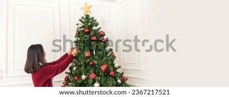 Banner Woman hands decorate Christmas tree red ball bauble. Panorama hands holding red ball bauble decorate. Wide shot Asian woman decor christmas tree in xmas season celebration with Copy Space