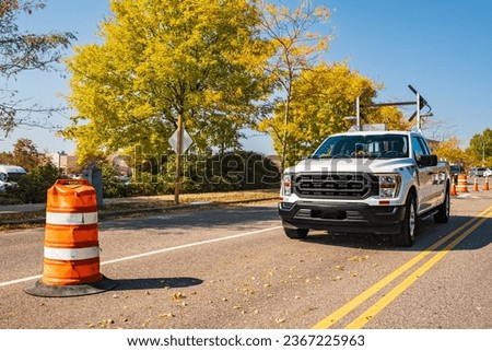 Road repair sign signal lights are flashing and detour with speed limit on a service truck. Directional portable traffic lights have been mounted to the back of the road construction companies vehicle