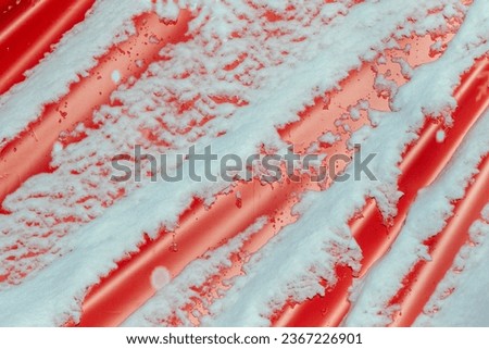 snow lies on a background of red fabric