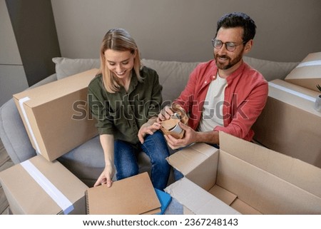 Two people looking busy while packing the boxes for relocation Royalty-Free Stock Photo #2367248143