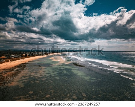 Aerial shot of beach and ocean with a cloudy sky
