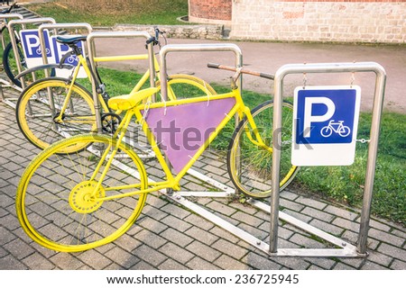 Yellow vintage bicycle in metal rack in the old town of Riga