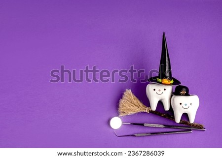 dental concept. tooth figurine in halloween costume and dental tools. pumpkins and a broom.on a purple background