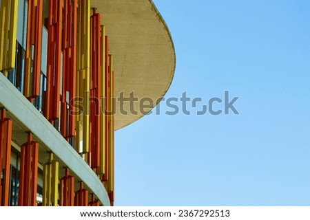 Rounded corner of a modern building with lined architectural elements.