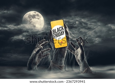 Zombie hands coming out of the ground, one is holding a smartphone with Black Friday online shopping ad Royalty-Free Stock Photo #2367293941