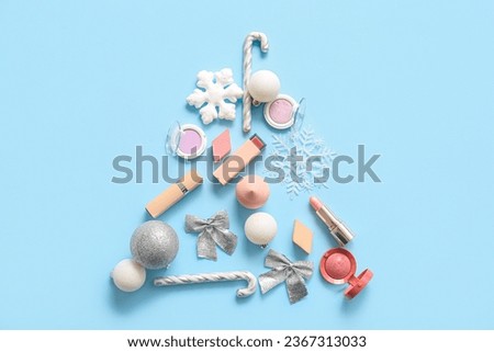 Christmas tree made of makeup products and decor on blue background