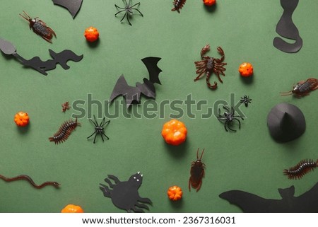Halloween composition with candy bugs, bats and pumpkins on green background