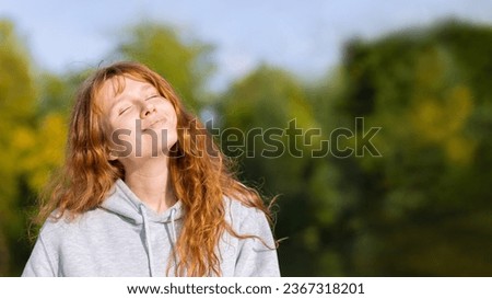 Beautiful young red haired woman in autumn park. Happy ginger girl resting, smiling in nature on background foliage, breathing fresh air with closed eyes. female portrait autumn.