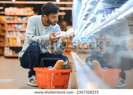 Portrait of handsome young Indian man standing at grocery shop or supermarket, Closeup. Selective Focus Royalty-Free Stock Photo #2367328255