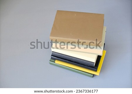 stack of books on grey background, top view. space for text