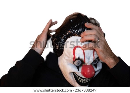 Person putting on Halloween mask that looks like a clown 