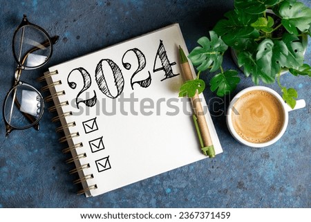 New year resolutions 2024 on desk. 2024 resolutions list with notebook, coffee cup on table. Goals, resolutions, plan, action, checklist concept. New Year 2024 template, copy space Royalty-Free Stock Photo #2367371459