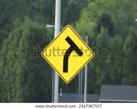T intersection with curve exit ahead yellow road sign highway