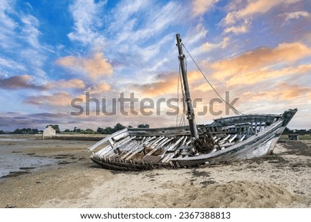 Brittany, Ile d Arz in the Morbihan gulf, a wreck ship on the beach, with the traditional tide mill in background Royalty-Free Stock Photo #2367388813