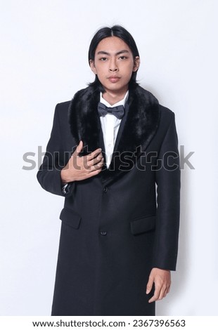 portrait of handsome male wearing black fur coat , posing on white background