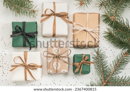 Christmas gift boxes made of craft paper on a white background and fir branches. Christmas background pattern, Boxing Day. Royalty-Free Stock Photo #2367400815