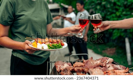 Home Garden BBQ Party, Wine Glasses Clink in Family Toast, enjoying harvest time together outside at front of house, grandfather and grandfather asian people, man and woman